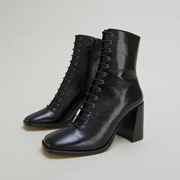 Heeled ankle boots with laces in black distressed leather