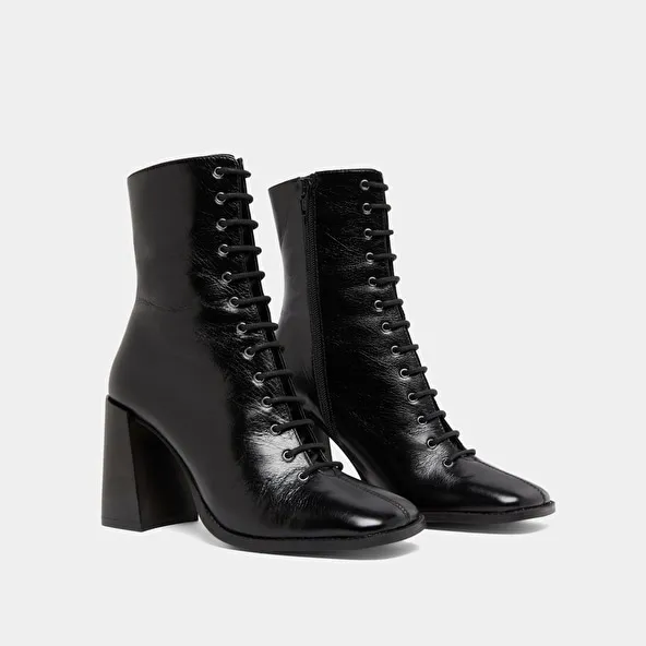 Heeled ankle boots with laces in black distressed leather