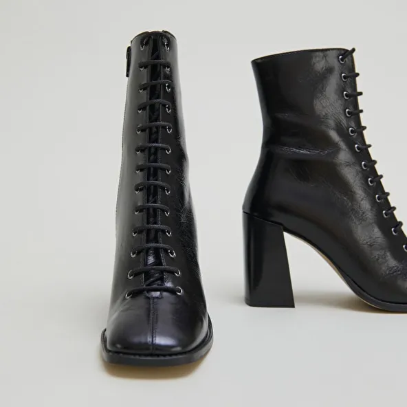 Heeled ankle boots with laces in black distressed leather